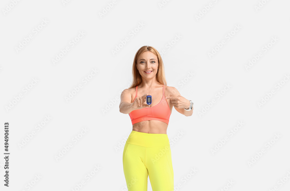 Female runner with pulse oximeter on light background