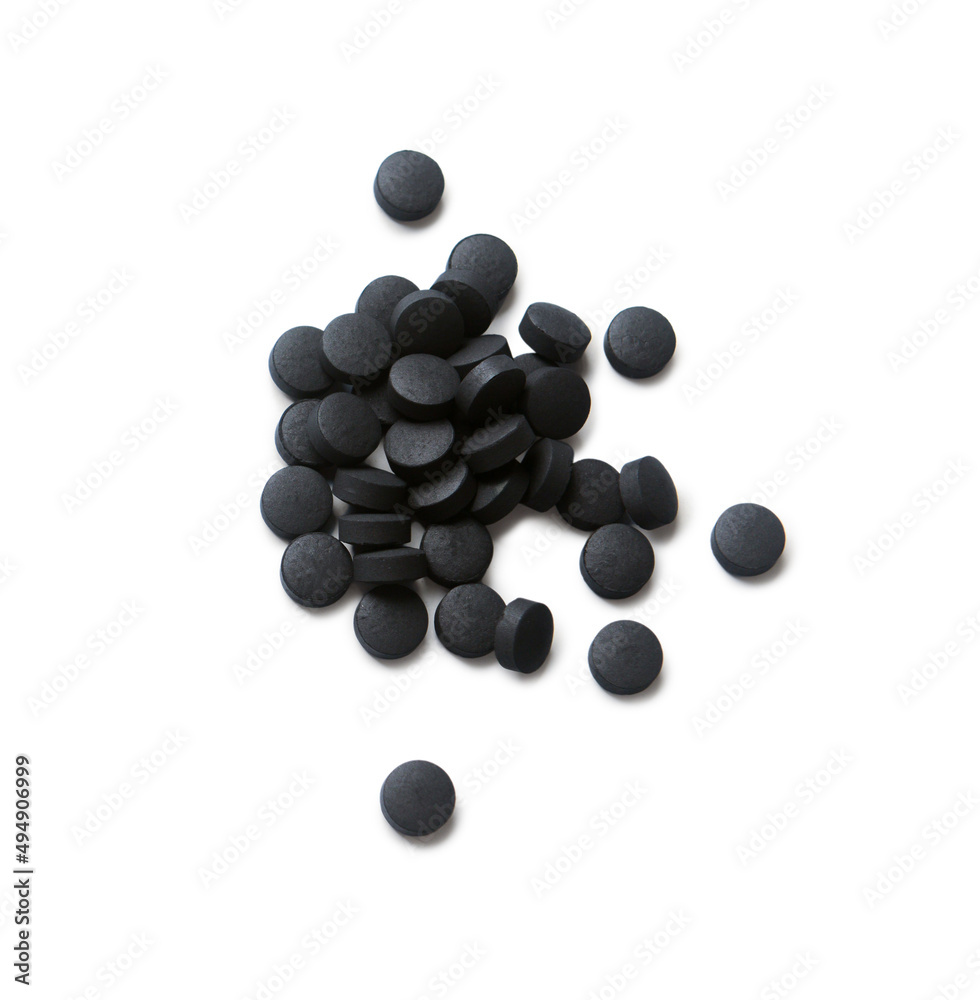Heap of activated carbon pills isolated on white background Heap of activated carbon pills isolated on white background