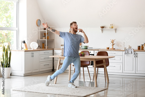 Cool young man dancing and singing at home