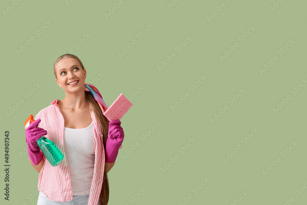 Young woman with sponge and detergent on color background