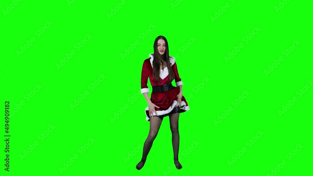 Slow motion of an attractive model in Christmas costume taking a spin in front of a green screen Slow motion of an attractive model in Christmas costume taking a spin in front of a green screen