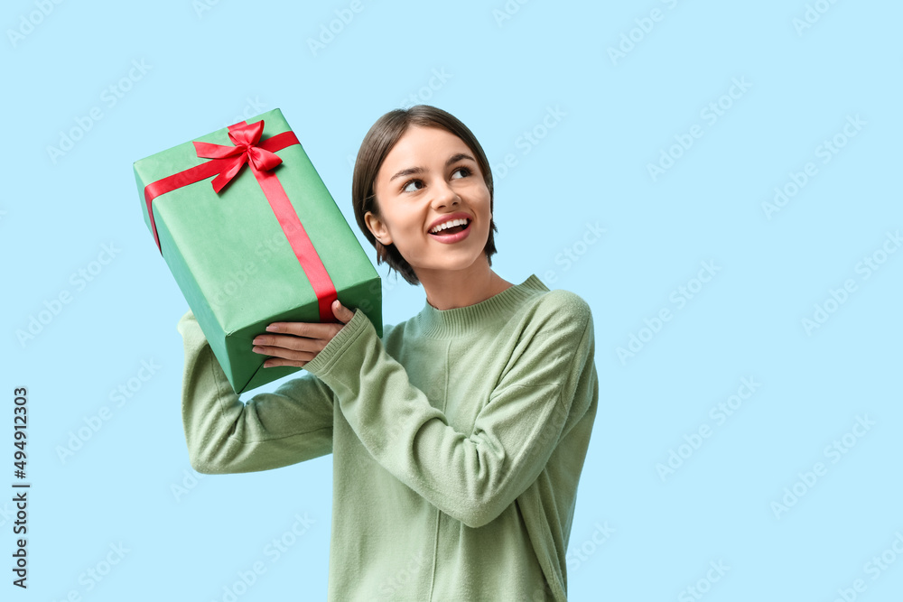 Beautiful woman holding gift box on color background Beautiful woman holding gift box on color background