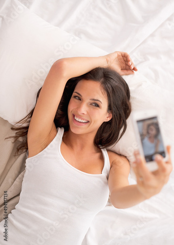 Posing in bed. Shot of a young woman in her bedroom.