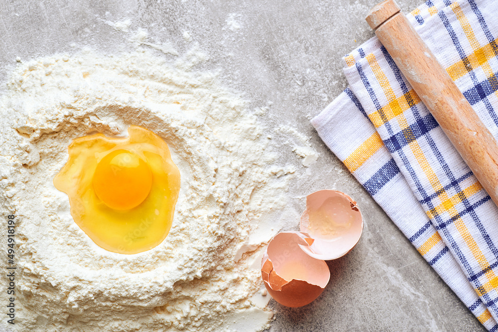 Baking ingredients. Flat lay composition with ingredients for making dough. Flour and eggs on rustic table background with copy space Baking ingredients. Flat lay composition with ingredients for making dough. Flour and eggs on rustic table background with copy space