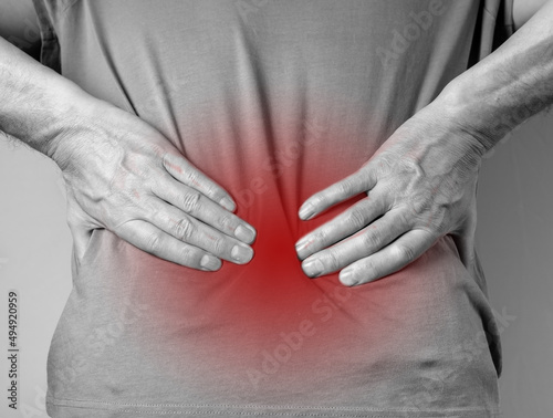 Lower back pain. Man hands holding red painful spot closeup. Sedentary lifestyle, injury, chronical illness, inconvenient posture. High quality photo photo