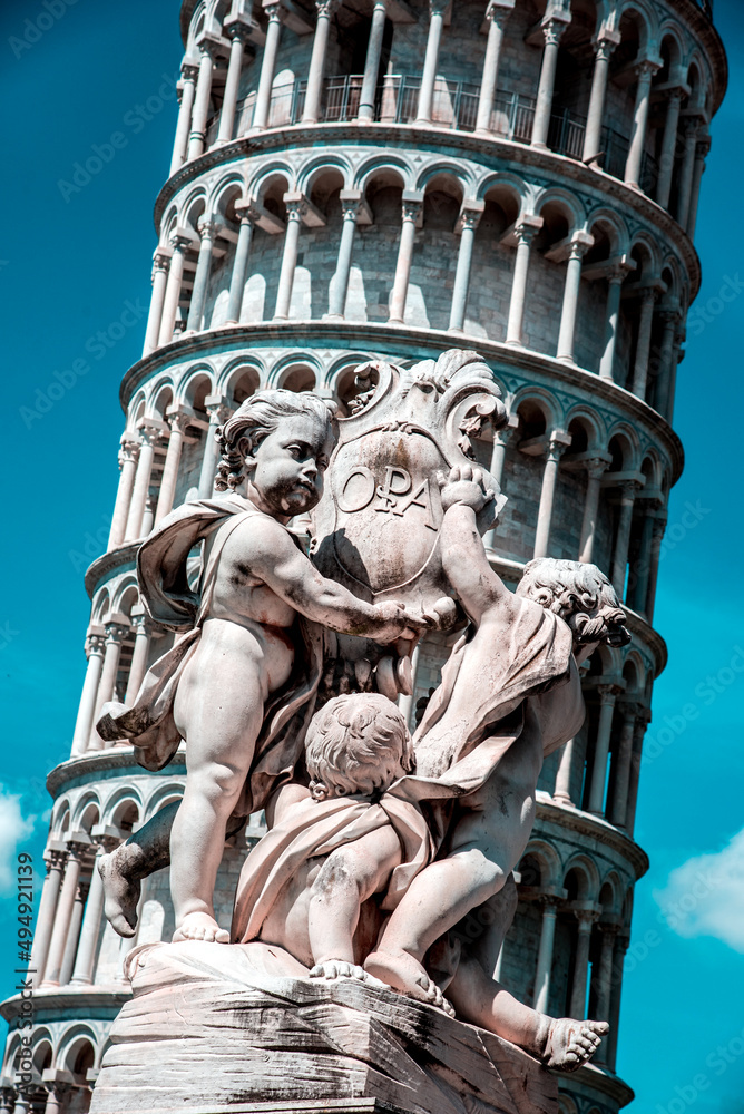 Monument on the background of the famous sloping tower with columns in Pisa, Italy. fascinating exotic amazing places.
