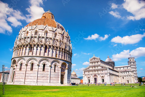 Fototapeta Picturesque landscape with San Giovanni Baptistery, part of cathedral or Duomo di Santa Maria Assunta near famous Leaning Tower in Pisa, Italy