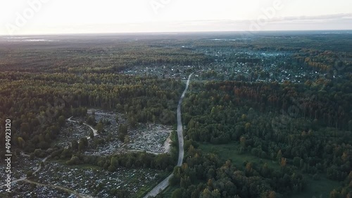 The road to the Russian village in the forest woods on a foggy morning in the light of the rising sun