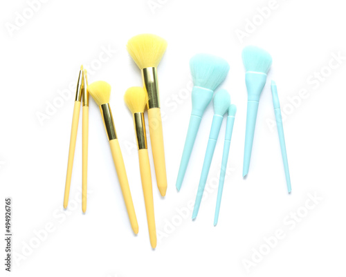 Set of blue and yellow makeup brushes isolated on white  top view