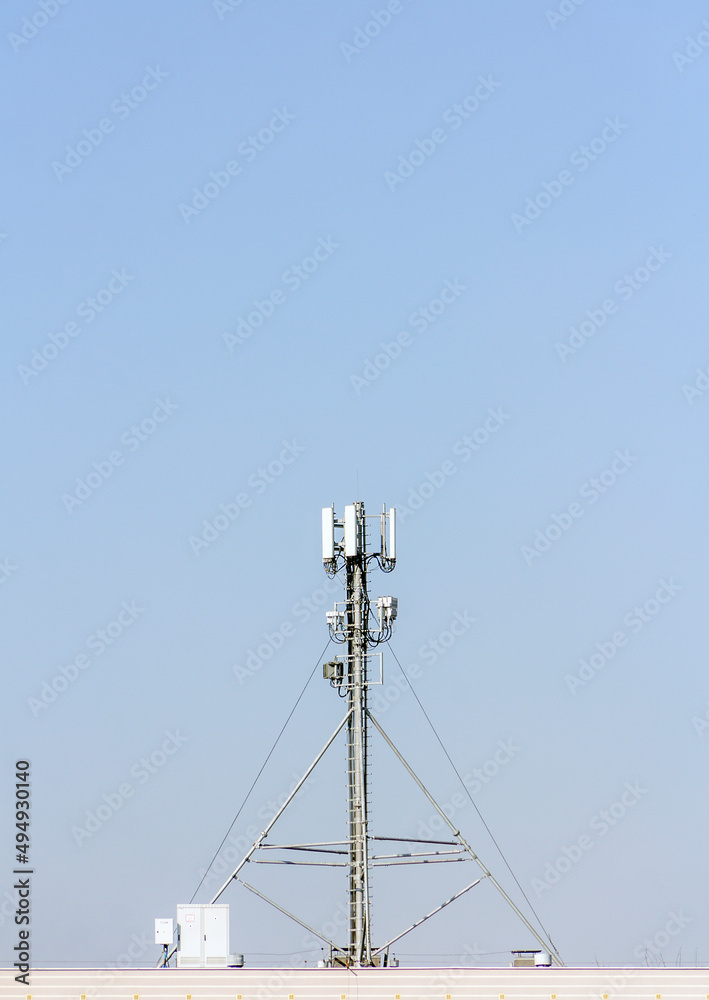 5g mobile telephone relay standing on the roof of a residential building 5g mobile telephone relay standing on the roof of a residential building