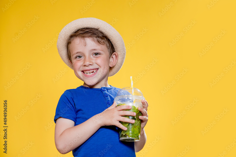 Portrait of a beautiful boy. Happy child. European boy in a hat, summer t-shirt with lemonade. Summer, vacation, vacation, sun, heat, sea, beach. Face for advertising. Portrait of a beautiful boy. Happy child. European boy in a hat, summer t-shirt with lemonade. Summer, vacation, vacation, sun, heat, sea, beach. Face for advertising.