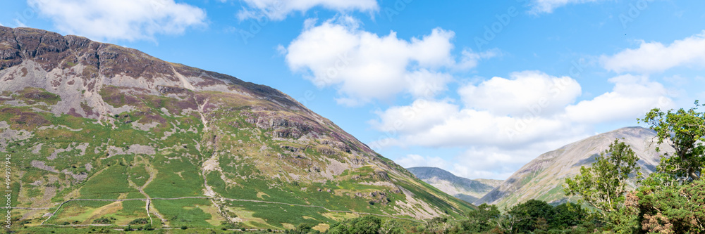 Wast Water or Wastwater is a lake located in Wasdale, a valley in the western part of the Lake District National Park, England, UK, beautiful summer day and blue cloudy sky Wast Water or Wastwater is a lake located in Wasdale, a valley in the western part of the Lake District National Park, England, UK, beautiful summer day and blue cloudy sky