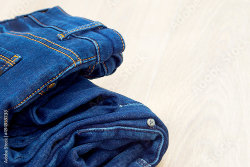 Blue jeans on a white background. Lots of jeans. Denim close-up. Fashionable blue stylish clothes. Pressed jeans. Jeans store.