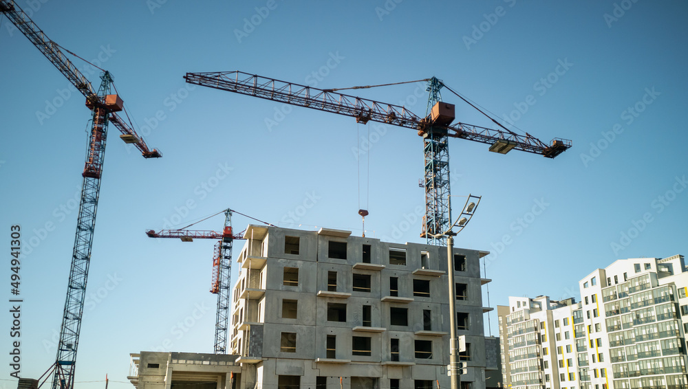 Tower cranes at the construction site. Construction of panel high-rise buildings.