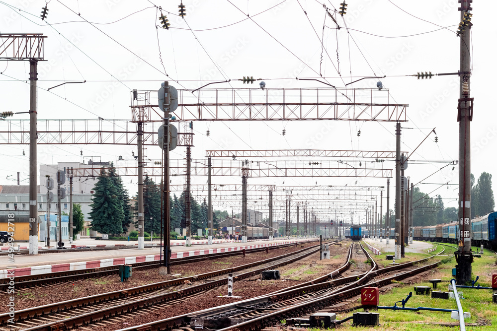 Railway station with rails, buildings and trains in the distance Railway station with rails, buildings and trains in the distance