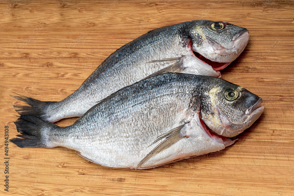 Gilt-head bream fresh raw fish dorada without scales and gills, ready for cooking. Picture of dorade for the fish seafood market menu Gilt-head bream fresh raw fish dorada without scales and gills, ready for cooking. Picture of dorade for the fish seafood market menu