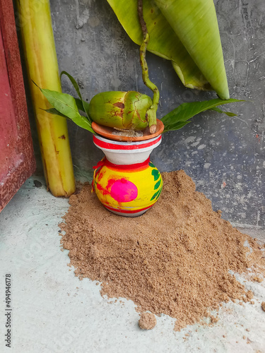 A Mangal Kalas With coconut and banana tree Leaves placed on sand outside a factory gate during Biswakarma puja or vishwakarma Puja - a Hindu god, the divine architect. Traditional way of prayer. photo