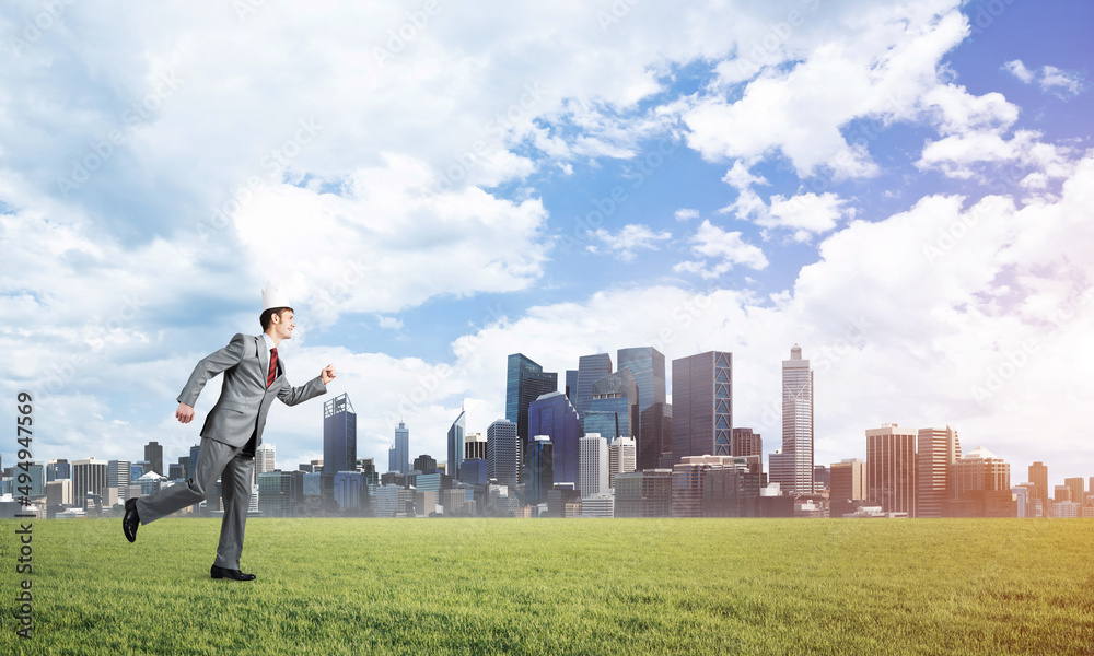 King businessman in elegant suit running on green grass and modern cityscape at background King businessman in elegant suit running on green grass and modern cityscape at background
