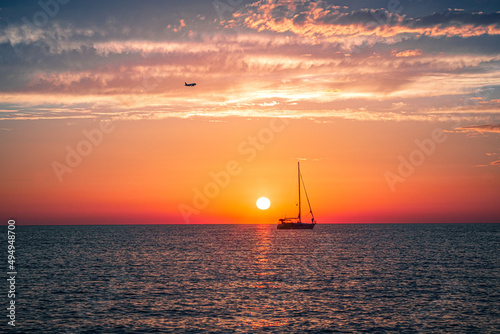 Fototapeta Naklejka Na Ścianę i Meble -  Silhouette of a ship sailing in the sea during sunset
