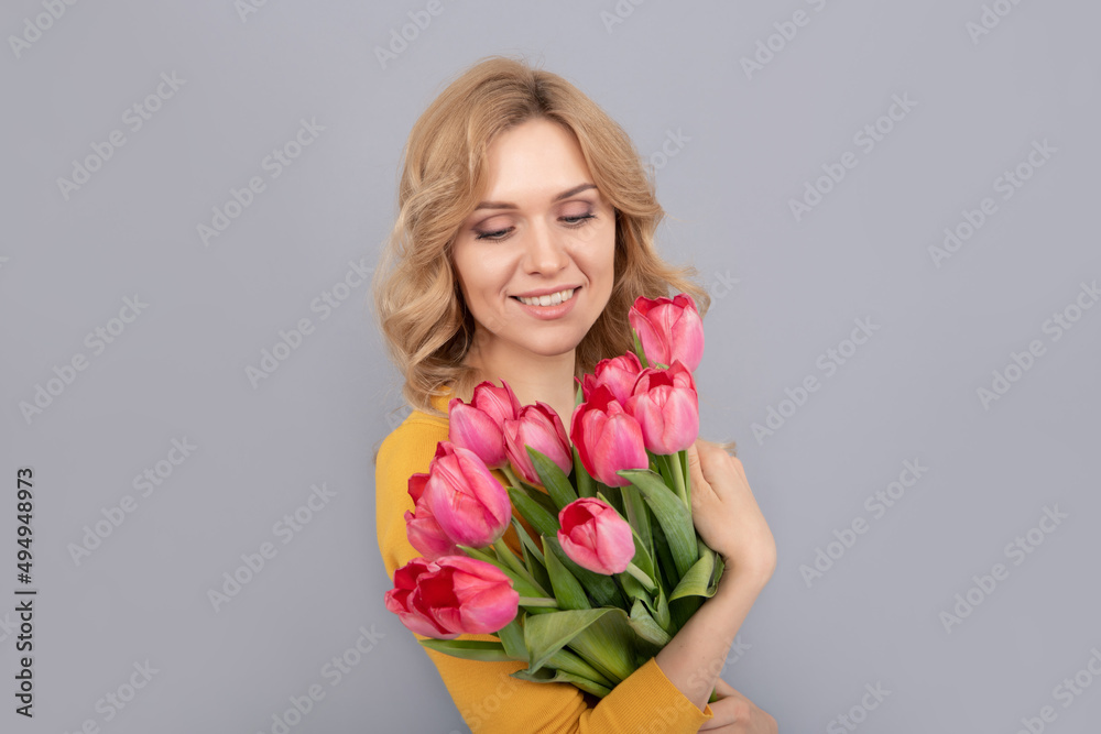 cheerful woman with tulips on grey background cheerful woman with tulips on grey background