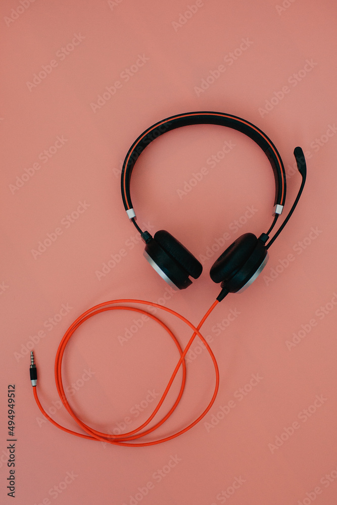 black headphone over pink color background,copy space. black headphone over pink color background,copy space.