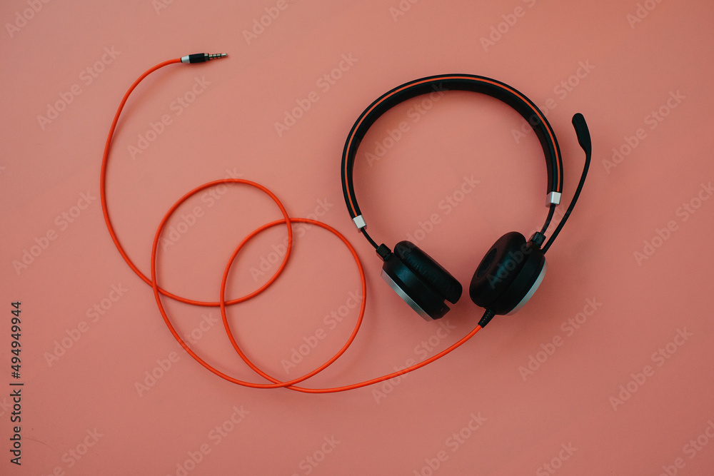 black headphone over pink color background,copy space. black headphone over pink color background,copy space.