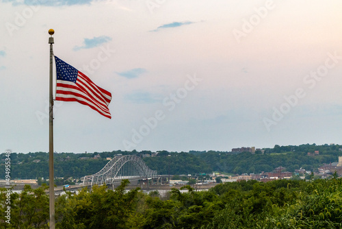 American flag and Julien Dubuque Bridge against blue sky in Dubuque city, Iowa, United States photo