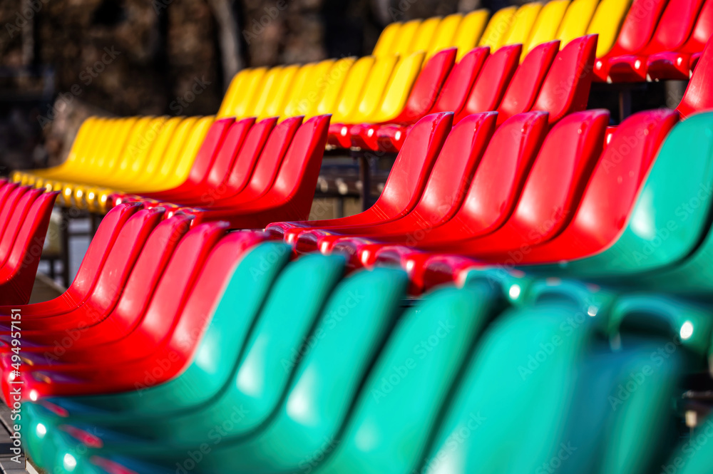 Obraz premium a fragment of the grandstand of an sports stadium with multi-colored chairs
