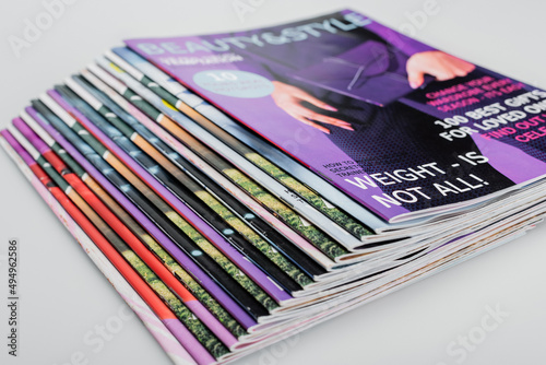 pile of beauty and style magazines on grey background, close up view. photo