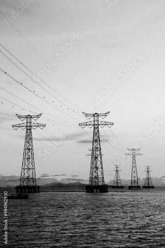 Beautiful shot of a bunch of electrical towers in a sea in grascale photo