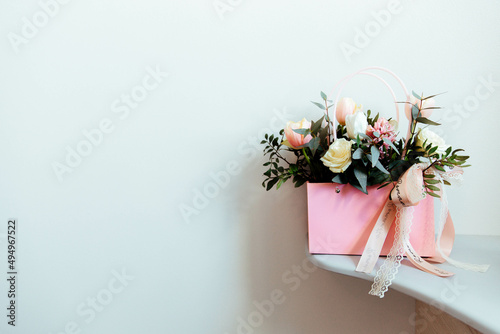 Bouquet of fresh flowers in pink is located on plain light background. The concept of a holiday, wedding, engagement, valentine's day, women's day, birthday or other events. 