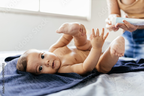 Photographie Mother changing baby's diaper in bed