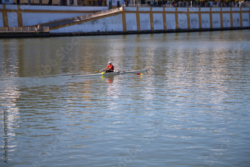 man riding a canoe for his daily training on the river in seville. Sport and health concept.