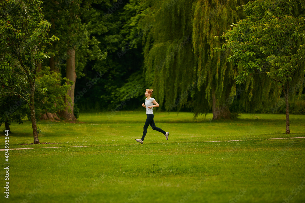 Lone runner. Shot of a woman jogging in a park.