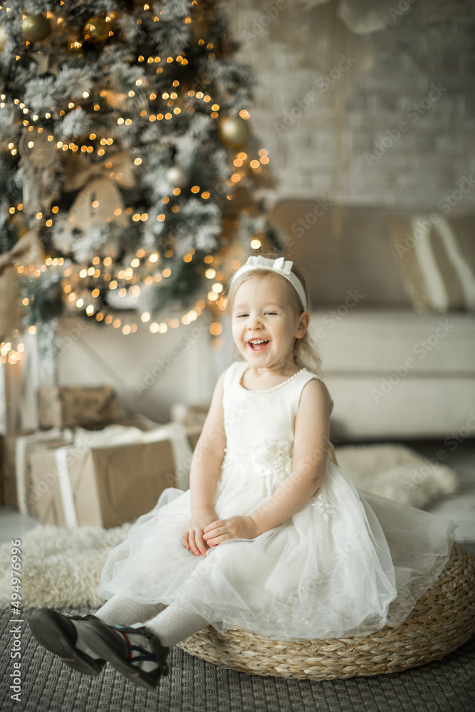 little girl rejoices in the new year. on the background of an elegant Christmas tree
