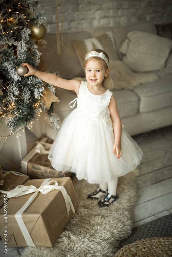 little girl rejoices in the new year. on the background of an elegant Christmas tree