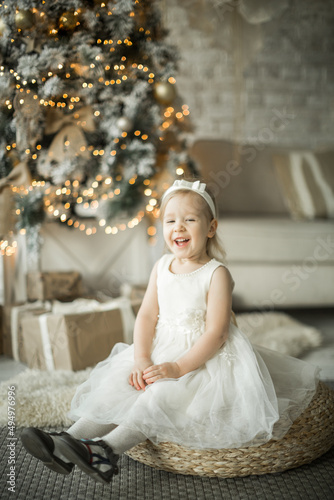 Obraz na płótnie little girl rejoices in the new year. on the background of an elegant Christmas tree w salonie
