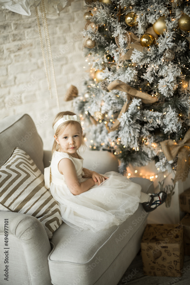 little girl rejoices in the new year. on the background of an elegant Christmas tree