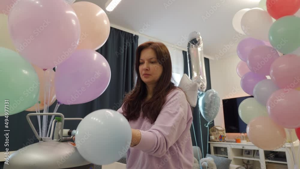 Woman using helium tank blowing up balloons to decorate home for party, colorful balloons for birthday wedding christmas party event decorations. High quality 4k footage