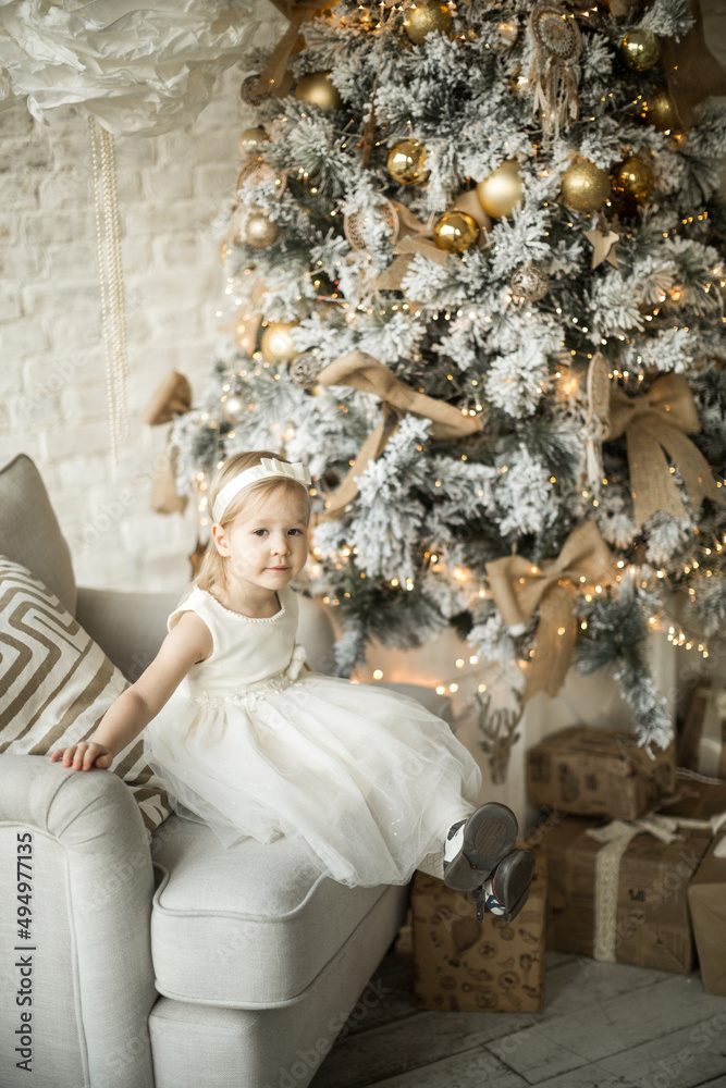 little girl rejoices in the new year. on the background of an elegant Christmas tree
