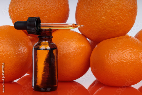 Orange extract has anti-cancer properties. A dropper on a background of fresh oranges. Natural remedies. photo