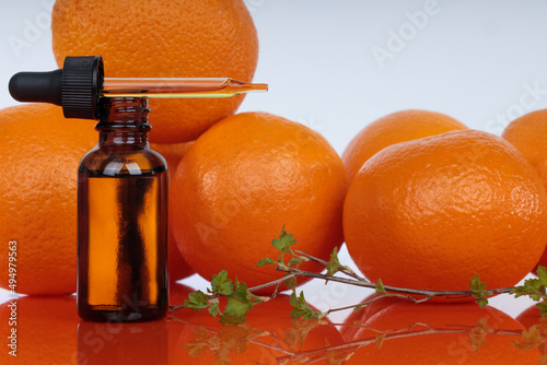 Bottle with essential oils, dropper with oil. Fresh oranges. A natural remedy for depression. photo