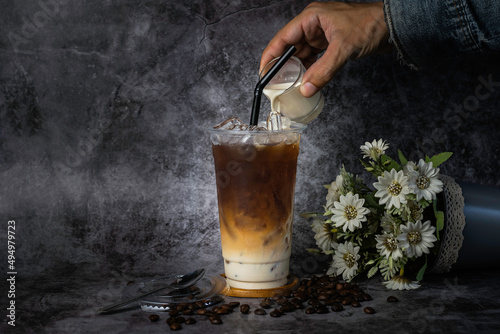 Thai coffee in a tall plastic cup There is steam next to the glass, cold. photo