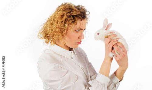 Beautiful girl with white baby rabbit. Friendship with Easter Bunny.