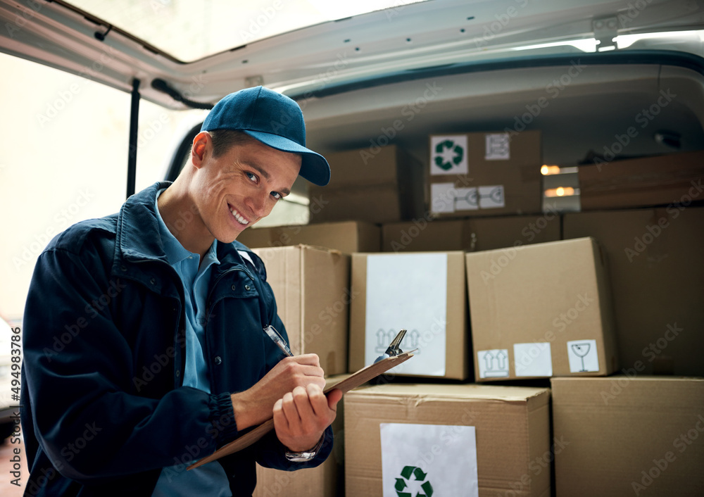 I make sure deliveries arrive on time. Cropped shot of a handsome young delivery man using a clipboard. I make sure deliveries arrive on time. Cropped shot of a handsome young delivery man using a clipboard.