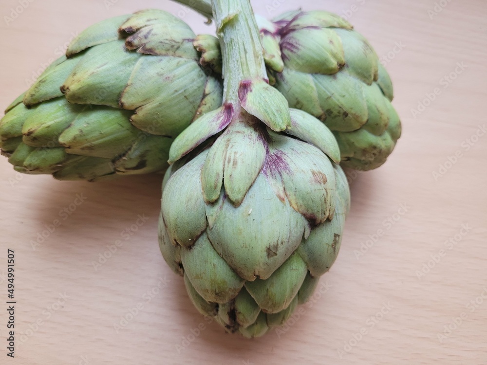Obraz premium artichokes on a wooden background. Fresh vegetables