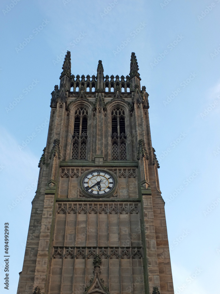a close up of the tower and clock of leeds parish church in west yorkshire