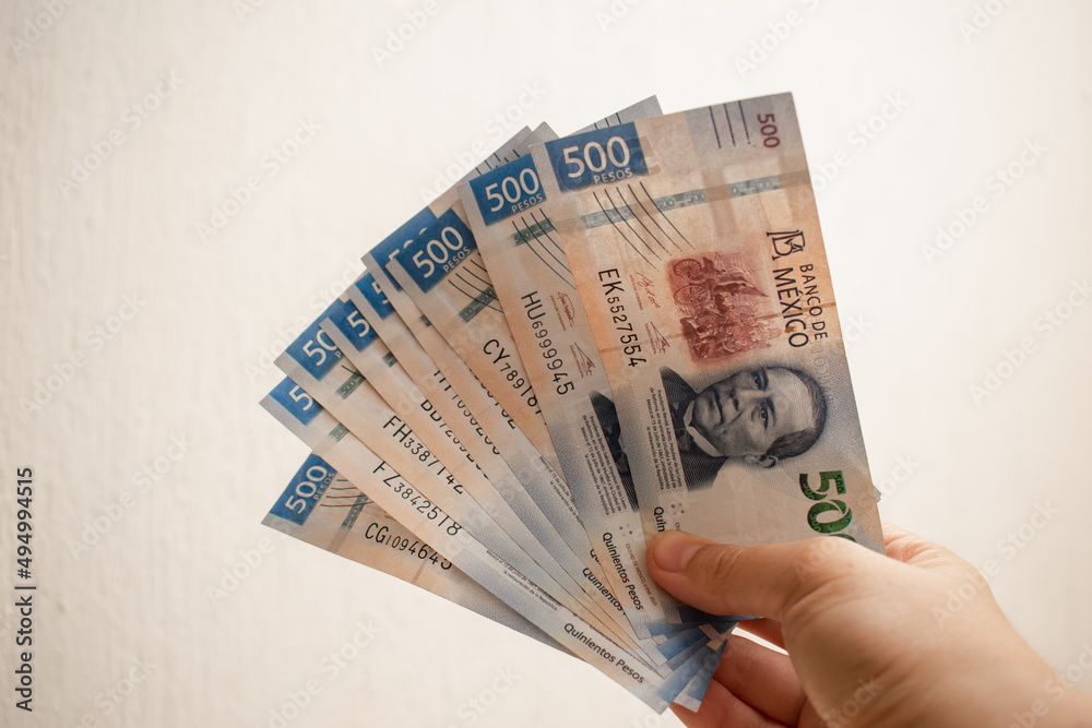 mano-sujetando-y-mostrando-billetes-de-quinientos-pesos-mexicanos-stock
