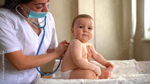 Female doctor listening to laughing baby boys patient heartbeat or breath, pediatrics concept