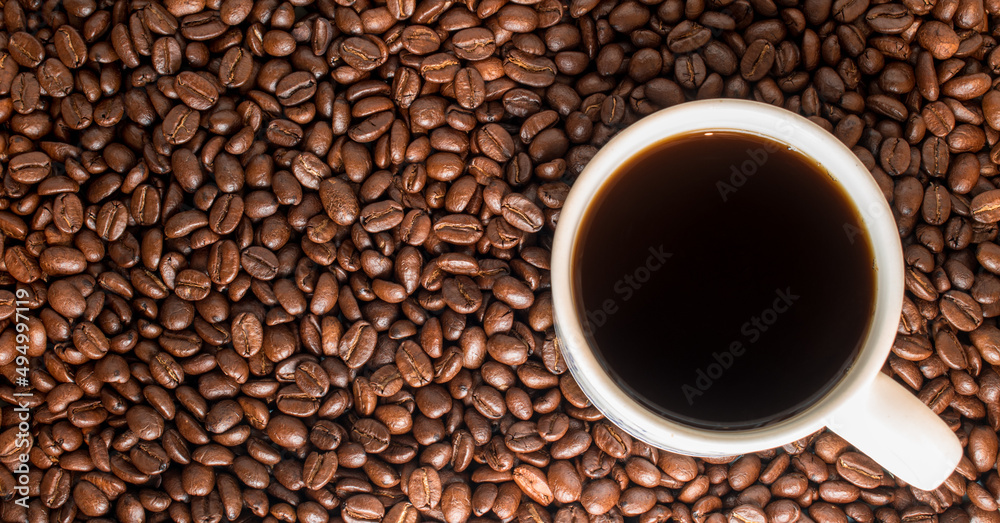 Black traditionl coffee cup on many coffee beans at background Black traditionl coffee cup on many coffee beans at background